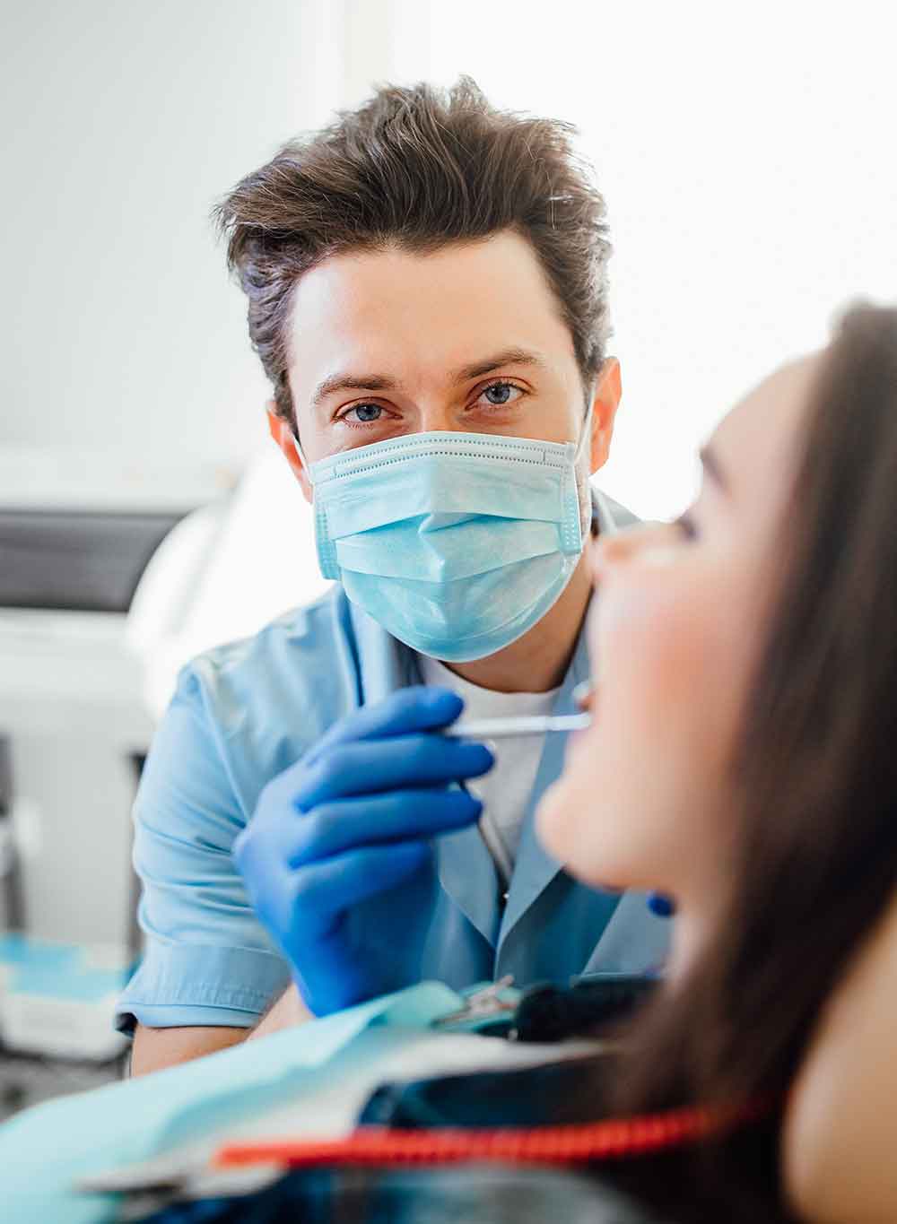 portrait dentist blue mask working with patient teeth modern clinic